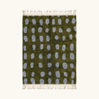 Full view of the Azil olive green and slate blue Beni Ourain rug with an oval grid design.