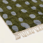 Angled view of the Azil olive green and slate blue Beni Ourain rug showing the oval grid design.