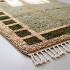 Corner of Mrirt rug showing checkered squares and fringe edge