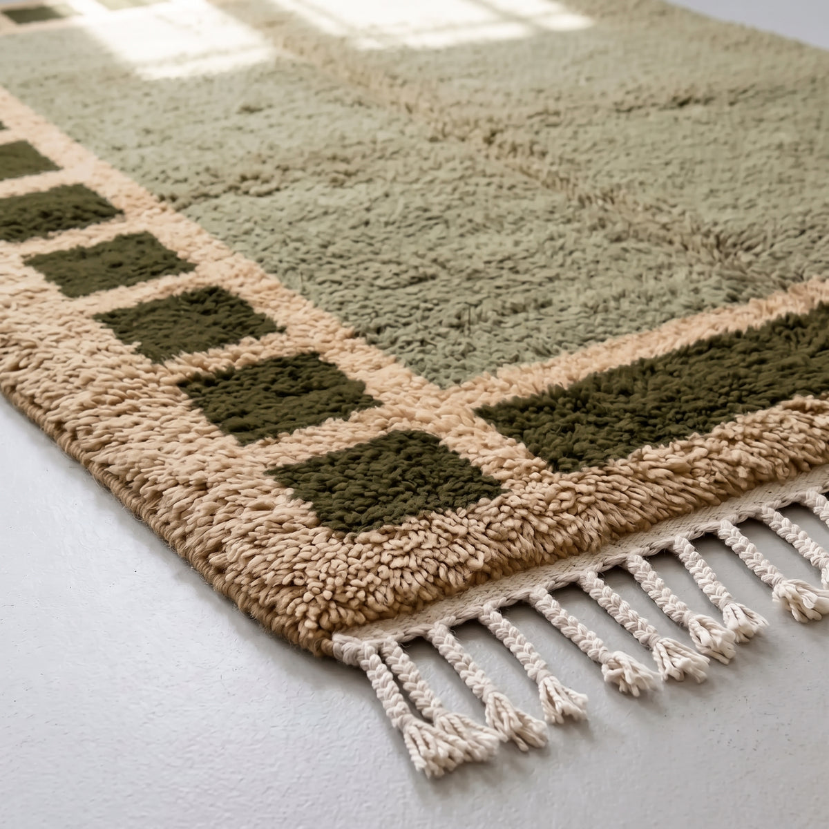 Corner of Mrirt rug showing checkered squares and fringe edge