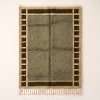 Olive and ivory Mrirt rug with checkered border frame design on plain background