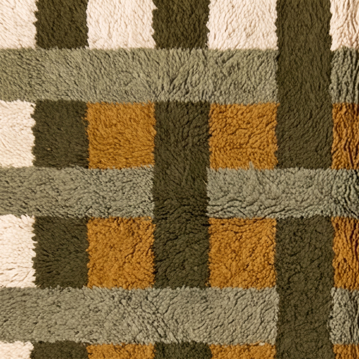 Detailed view of grid weave intersections in olive, mustard and ivory tones