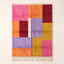 Zayna Azilal rug, full view on plain background, pink, orange, burgundy, lavender, mustard and cream colour blocks in asymmetric grid
