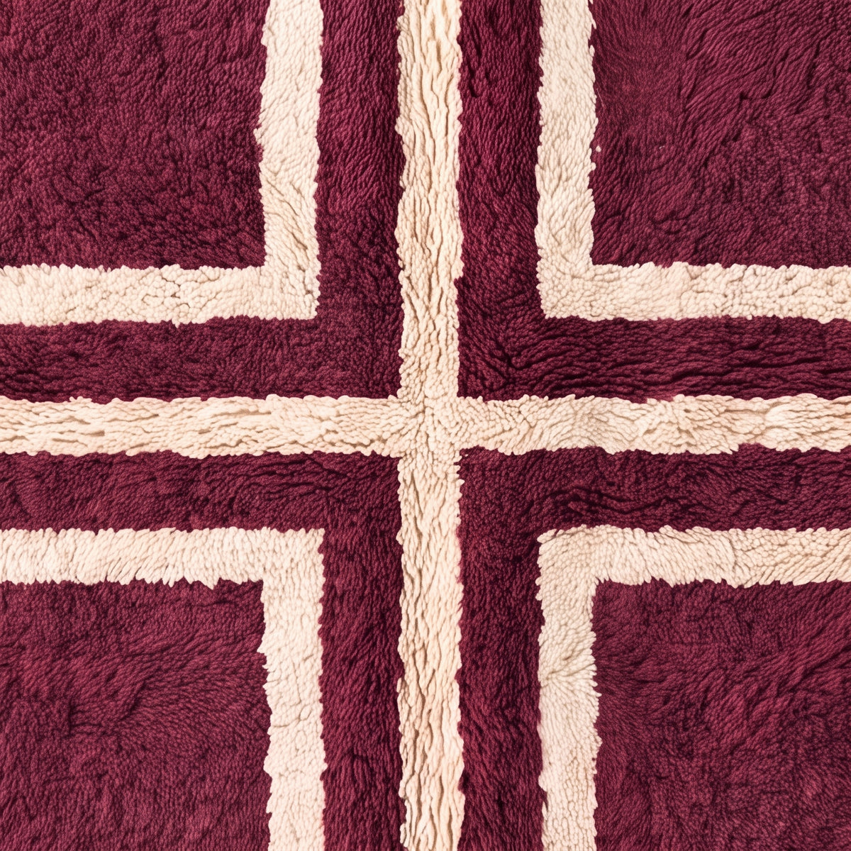 Close-up of plum Beni Ourain rug fringe and cross motif detail showing knot work and construction