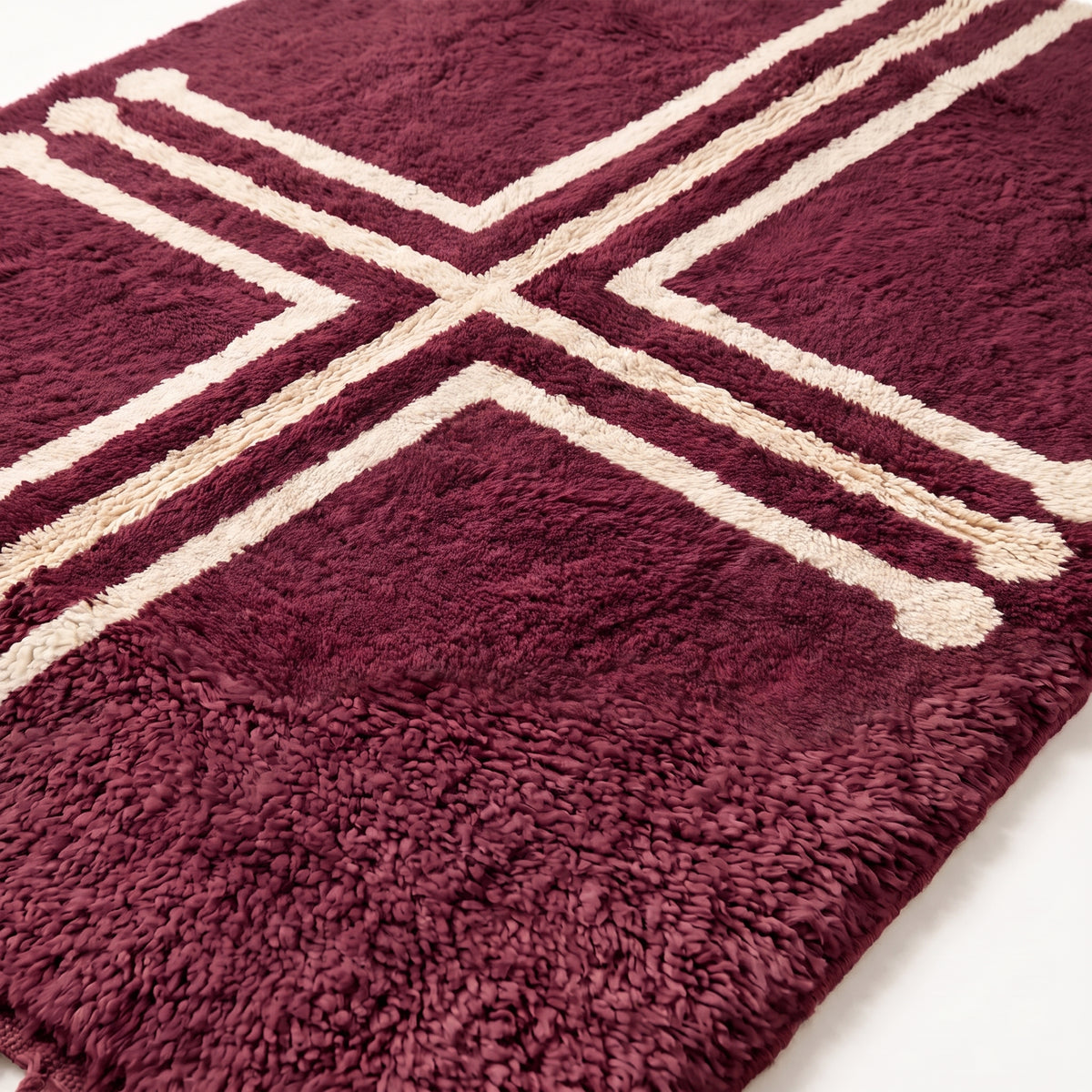 Close-up detail of plum Beni Ourain rug showing thick soft pile and ivory cross stripe texture
