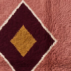 Close-up of diamond motif showing layered design with gold inner diamond outlined in burgundy with cream border