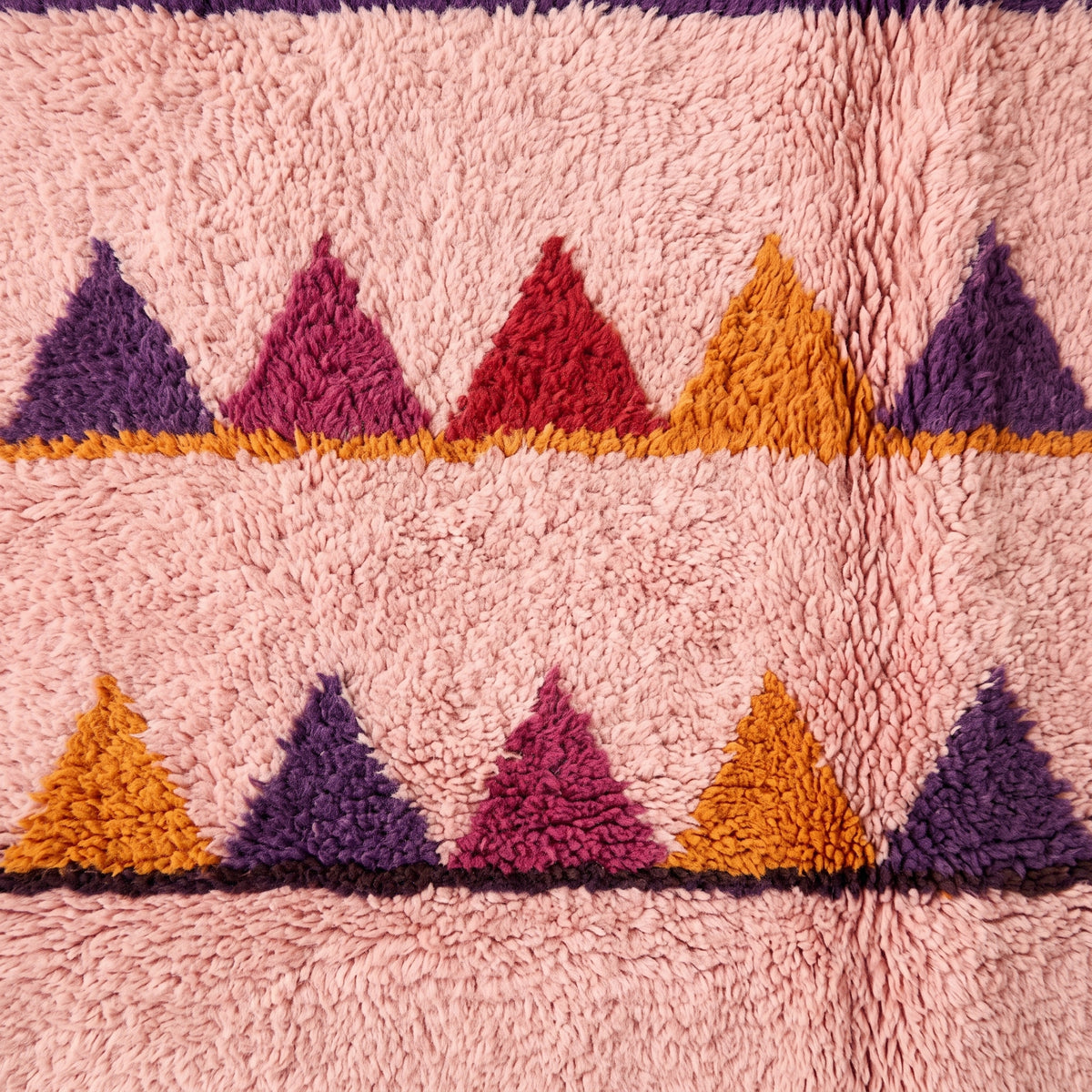 Fringe and edge detail of Boujaad sawtooth rug showing cream knotted fringe and triangle motif definition