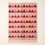 Rose Boujaad rug with horizontal sawtooth rows in crimson, purple, orange and magenta triangles, flat lay on plain background