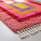 Angled pile detail of Menna Azilal rug showing soft wool texture and colour transitions across nested rectangle bands