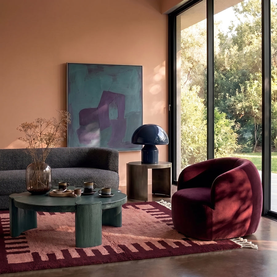 Rose & Wine Mrirt Crenellated Border rug in modern living room with green table, burgundy chair and peach walls