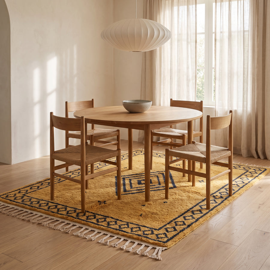Saffron and charcoal Beni Ourain rug in dining room setting with wood table and chairs
