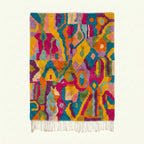 Full view of the Asirem saffron, magenta and turquoise Boujaad rug with a freeform abstract symbol design.