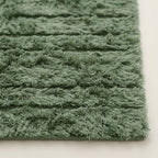Side angle of Tawenza rug showing depth and softness of sage green handwoven pile