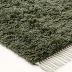 Angled pile detail of sage green Beni Ourain rug Talwit with ivory fringe edge