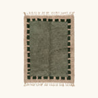Full view of the Ifru sage green, forest green and ivory Beni Ourain rug with a block border design.