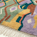 Fringe and edge detail of the Tafrar Boujaad rug with lilac, ochre and terracotta forms