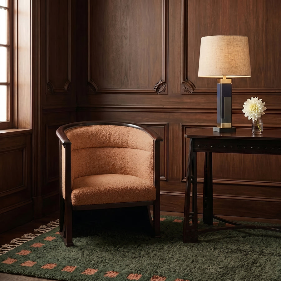 Sage and terracotta Mrirt rug in situ in wood-panelled room with mid-century chair