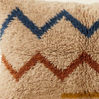 Side view of the Tasa Moroccan pillow showing its sand, navy and rust wool pile