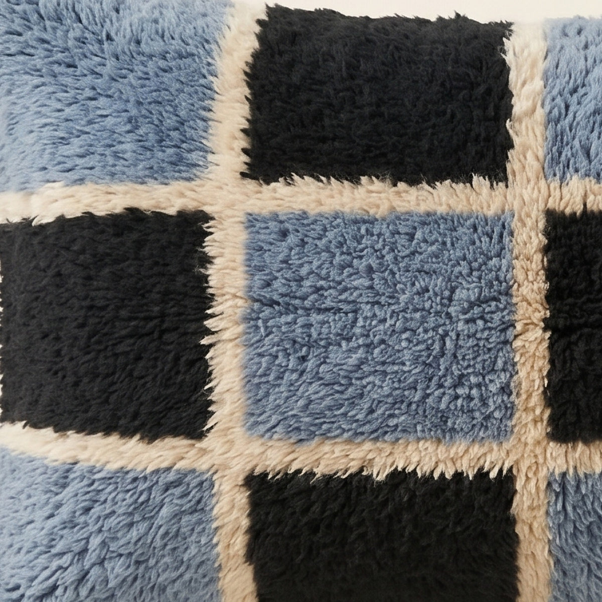 Side view of the Tisent Moroccan pillow showing its slate blue and black wool pile