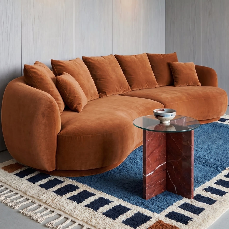 Slate blue Talwit rug with checkered border in modern living room with orange curved sofa