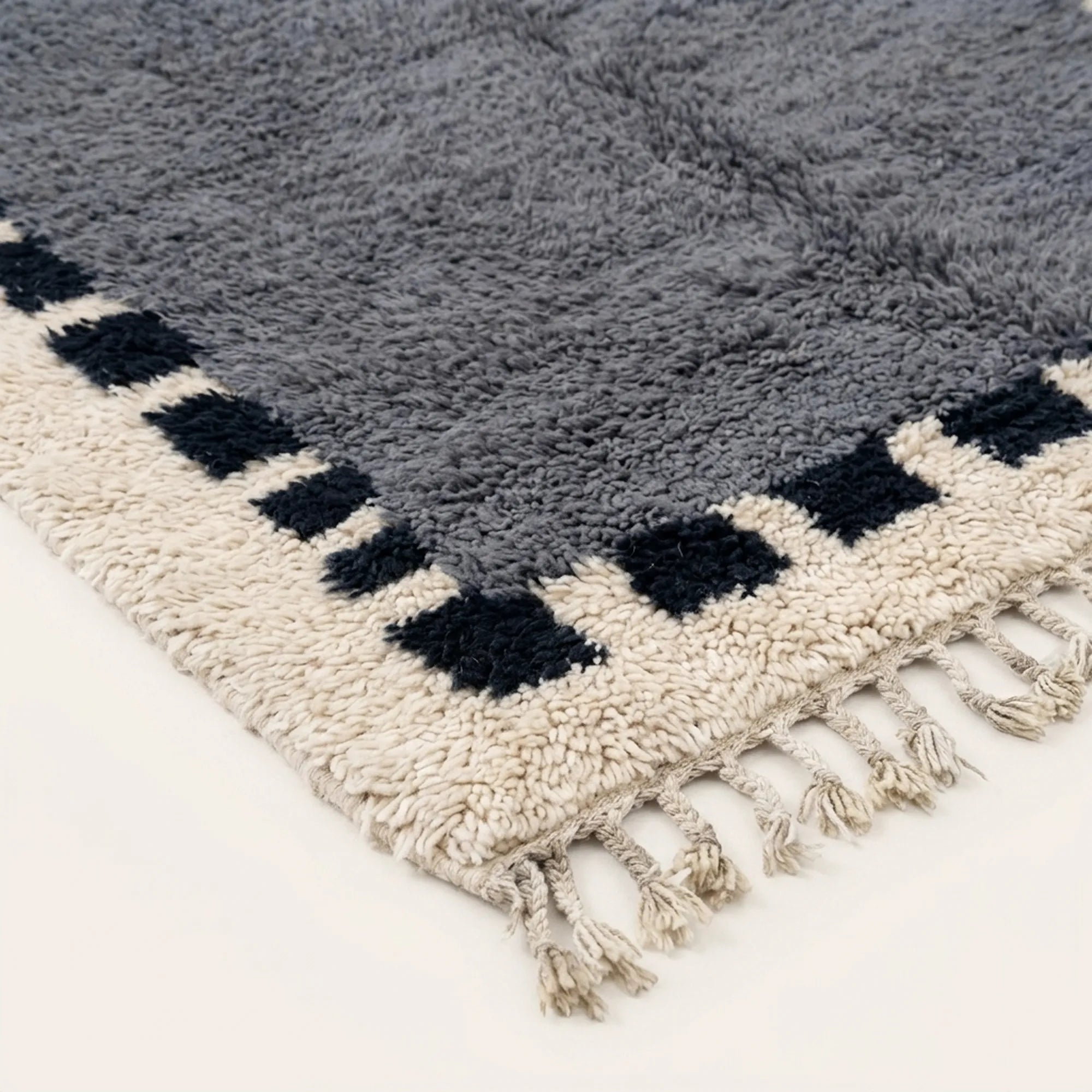 Fringe and edge detail of the Tamesna slate blue, navy and ivory Beni Ourain rug.