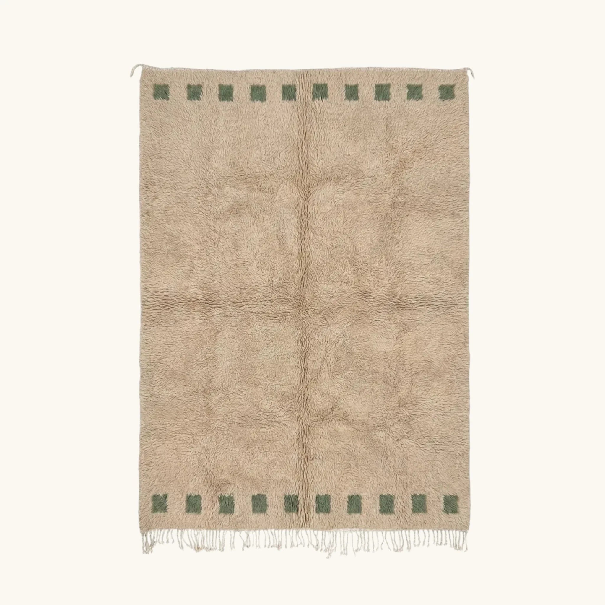 Full view of the Tala ivory Beni Ourain rug with a deep green border block motif and hand-tied fringe.