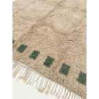 Close-up of the ivory field and deep green border block motif on the Tala rug.