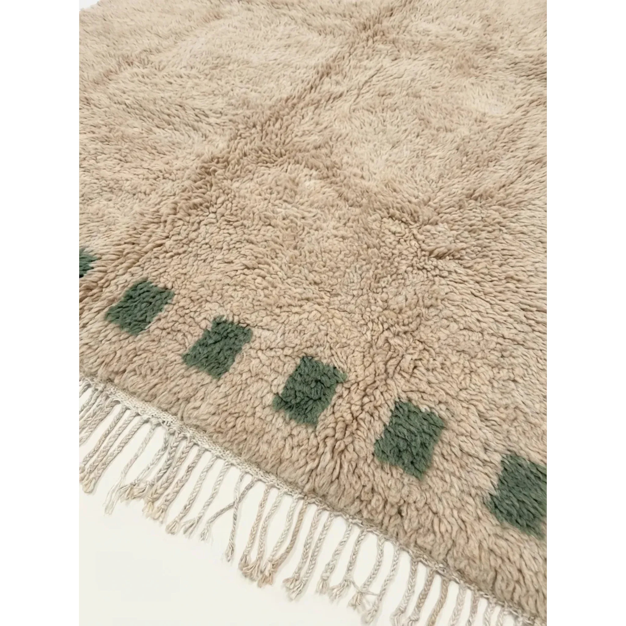 Close-up of the ivory field and deep green border block motif on the Tala rug.