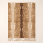 Tan and chocolate Beni Ourain rug with scattered ivory spots and fringe ends visible
