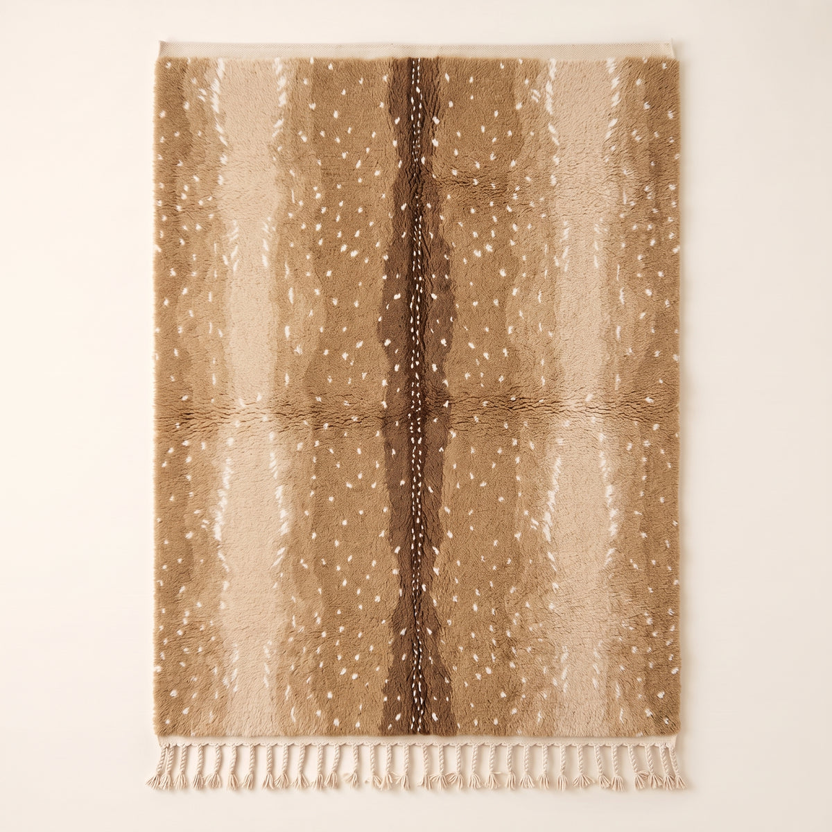 Tan and chocolate Beni Ourain rug with scattered ivory spots and fringe ends visible