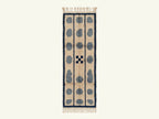 Flat lay of Tan, Slate Blue & Navy Mrirt runner showing three columns of slate blue pebbles separated by navy stripes with center cross-hatch motif