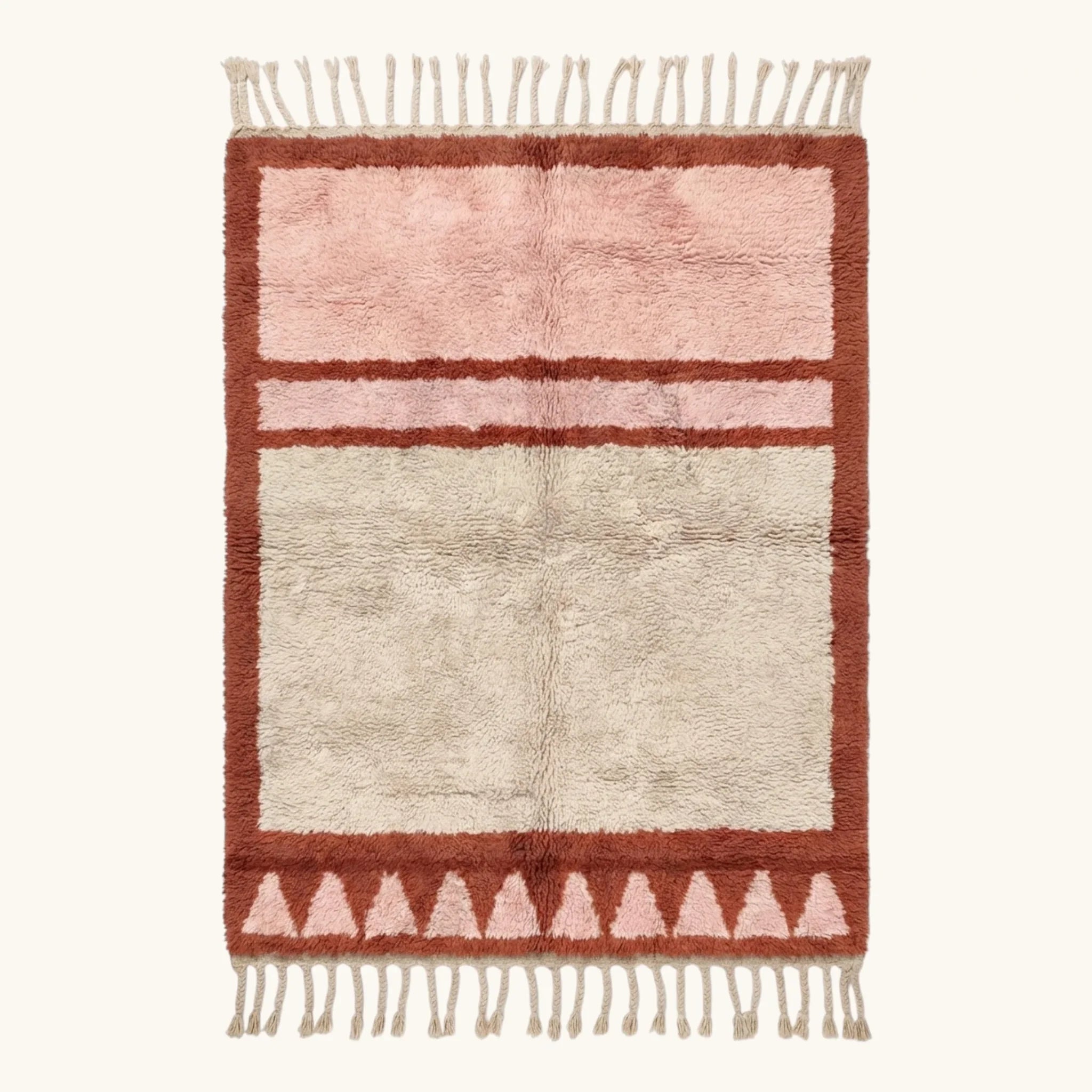 Full view of the Tanirt blush Beni Ourain rug with a framed triangle motif and hand-tied fringe.