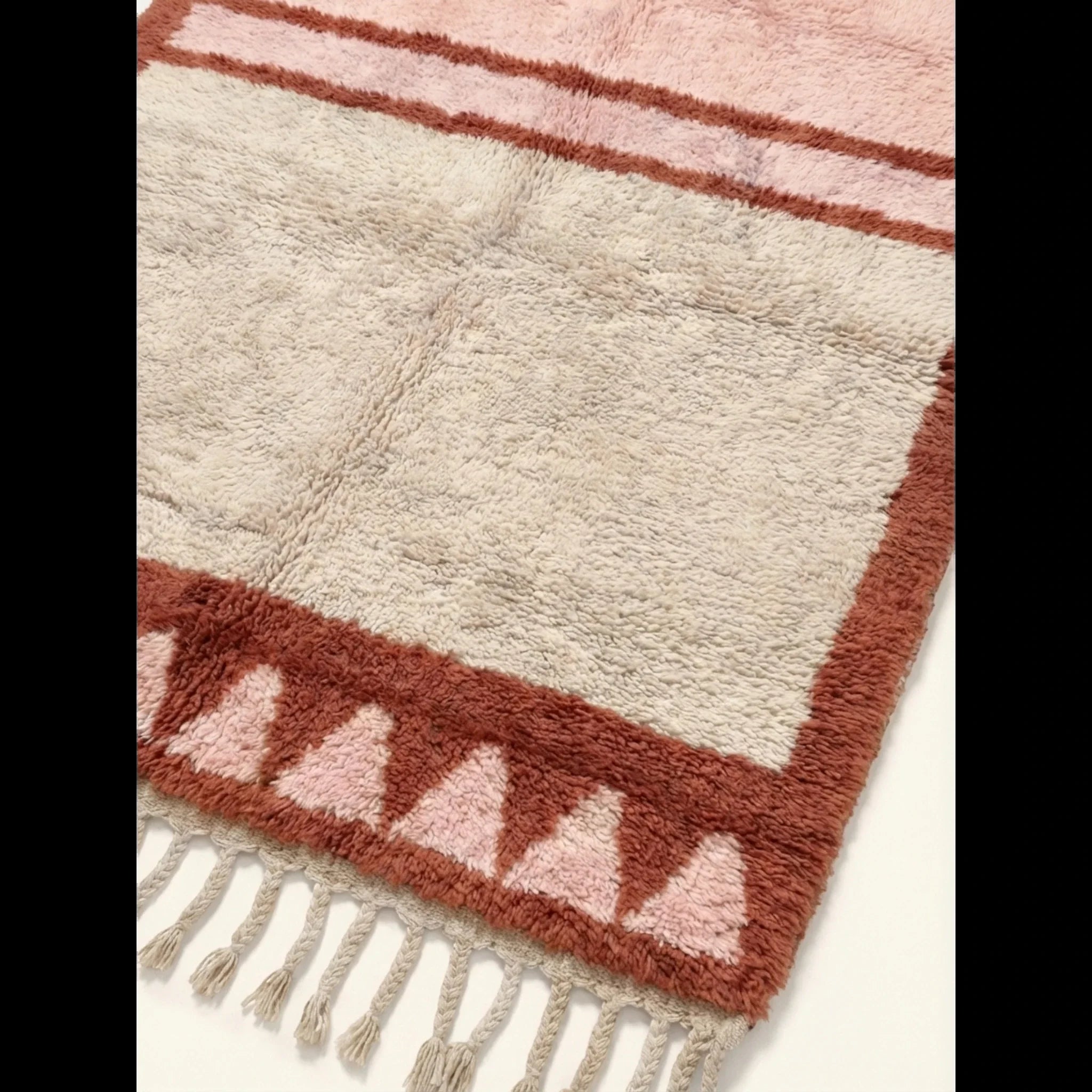Close-up of the blush and ivory framed triangle motif on the Tanirt rug.
