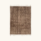 Full view of the Targa taupe Beni Ourain rug with small ivory cross motifs.