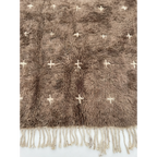 Close-up of the taupe wool pile and ivory cross motifs on the Targa rug.
