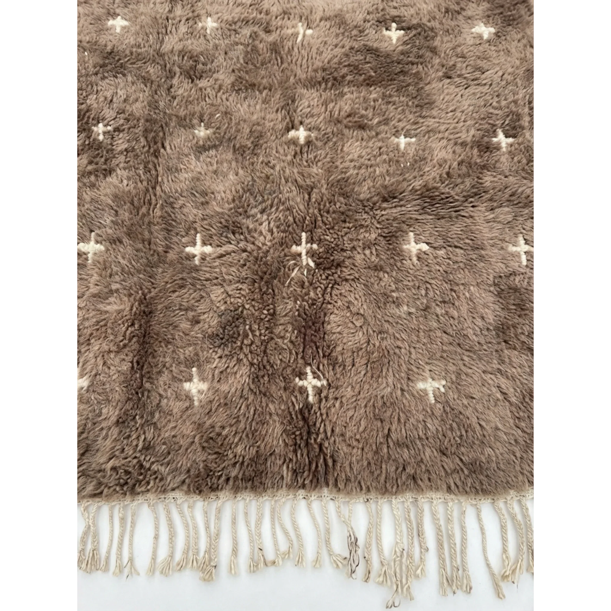 Close-up of the taupe wool pile and ivory cross motifs on the Targa rug.