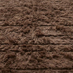 Detailed view of taupe Beni Ourain rug edge showing transition from deep pile to ivory twisted fringe