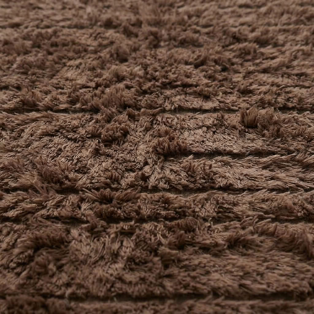 Detailed view of taupe Beni Ourain rug edge showing transition from deep pile to ivory twisted fringe
