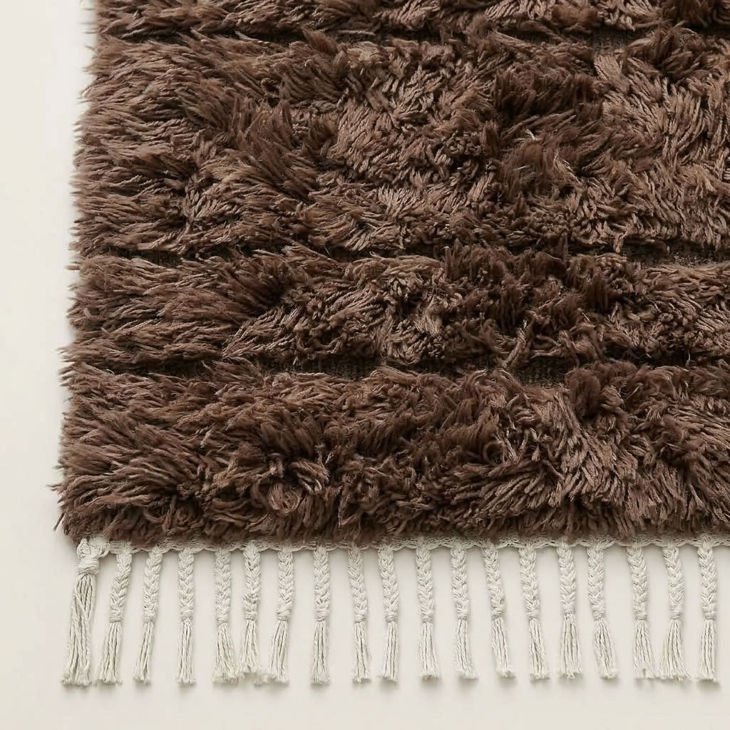 Close-up of taupe Beni Ourain pile texture showing thick, hand-knotted wool and ivory fringe detail