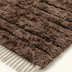 Extreme close-up of taupe Beni Ourain textured pile showing natural wool variation and knot structure