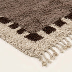 Close-up of the natural Atlas wool texture on the Awrir taupe, brown and ivory Beni Ourain rug.