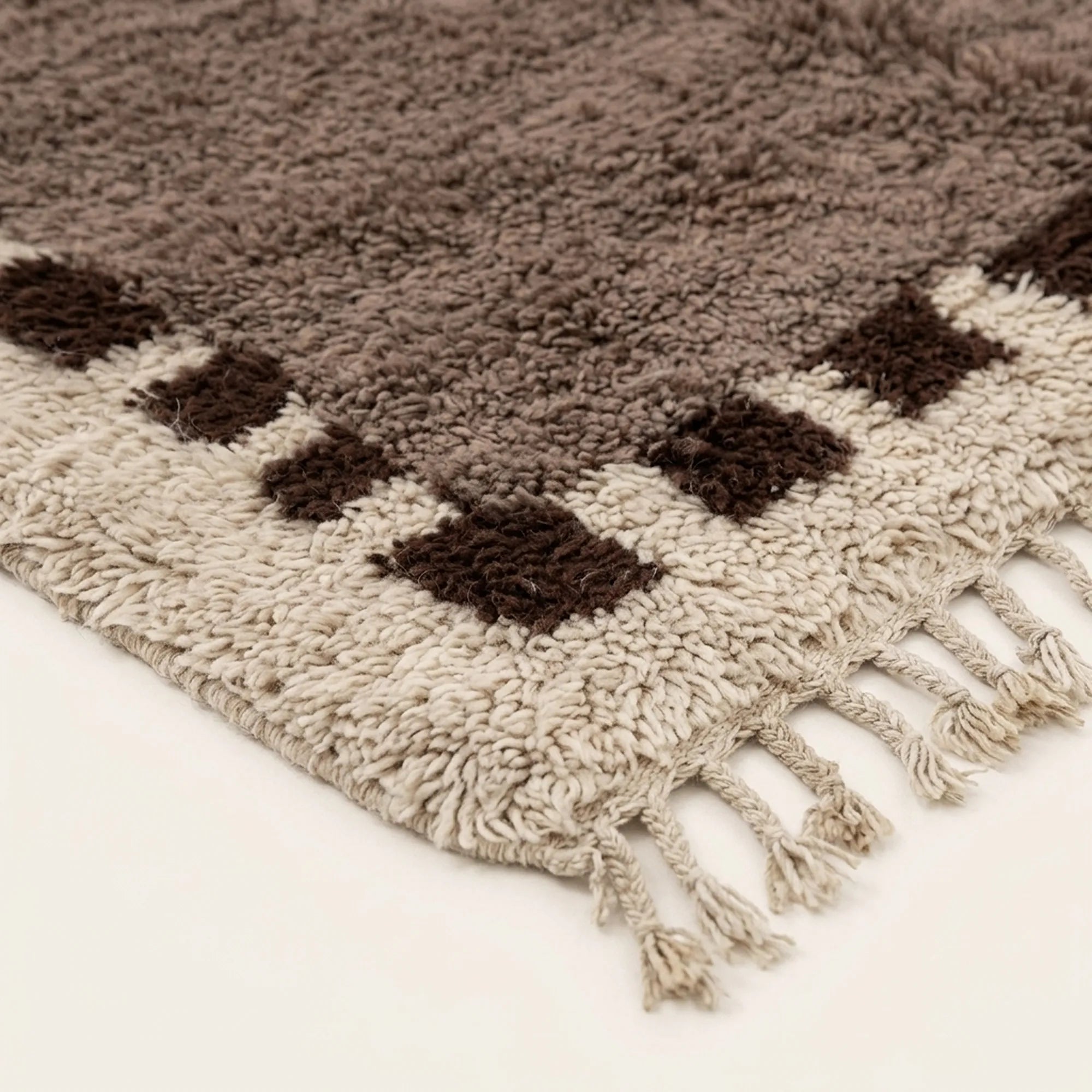 Close-up of the natural Atlas wool texture on the Awrir taupe, brown and ivory Beni Ourain rug.