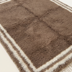 Dense natural Atlas wool pile texture of the Ayyur taupe and ivory Beni Ourain rug.