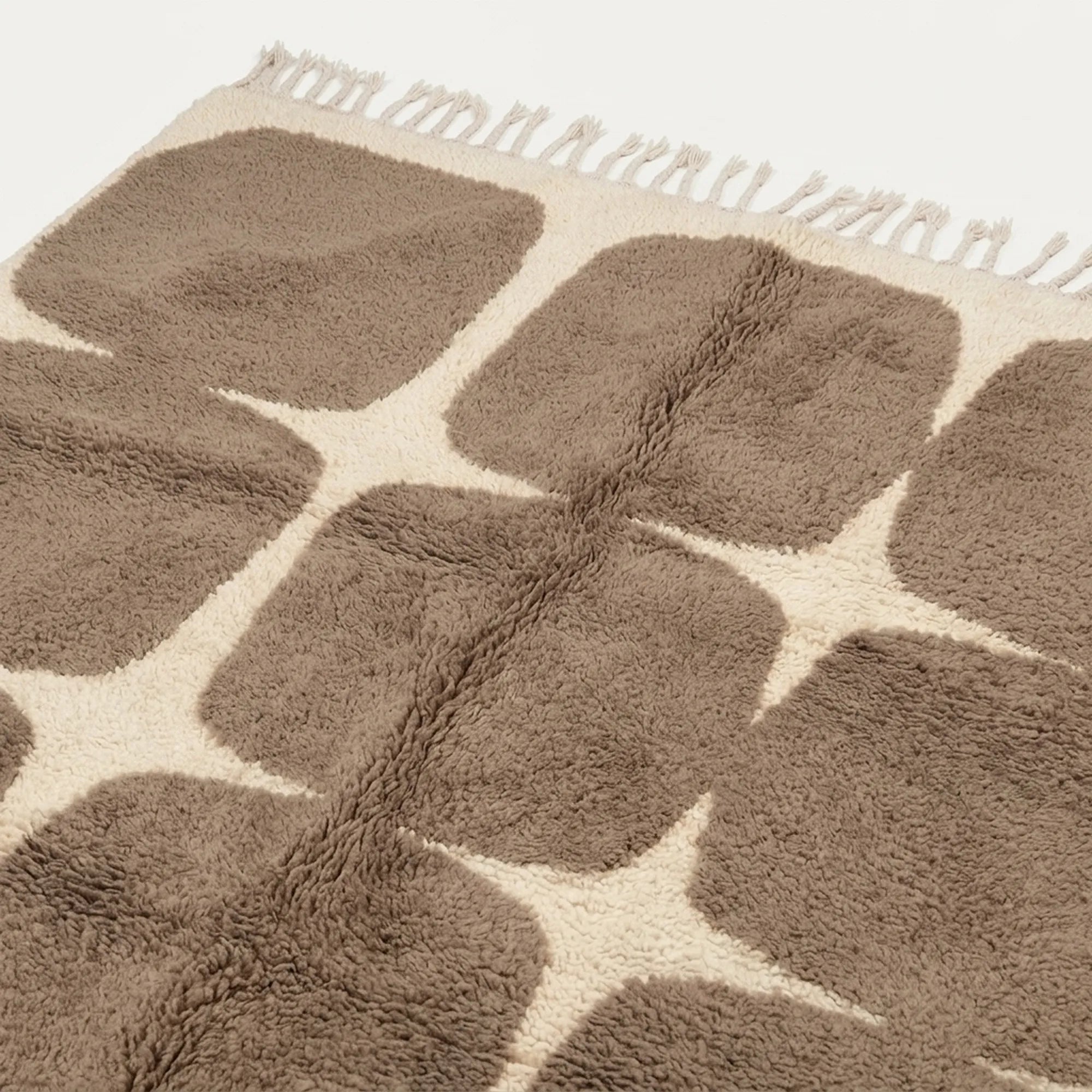 Angled view of the Asif taupe and ivory hand-knotted Beni Ourain rug.
