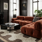 Tazrout taupe and ivory Beni Ourain rug styled beneath a rust velvet sectional in an elegant living room.
