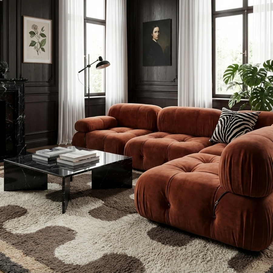 Tazrout taupe and ivory Beni Ourain rug styled beneath a rust velvet sectional in an elegant living room.
