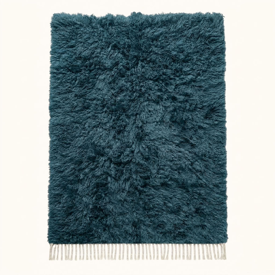 Flat lay of teal Beni Ourain rug with textured pile and ivory fringe