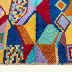 Close-up of the geometric patchwork diamond design on the Tifawt Boujaad rug.