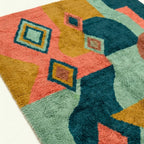 Pattern close-up of Tifawin showing outlined diamonds over teal, coral, ochre and sage color fields