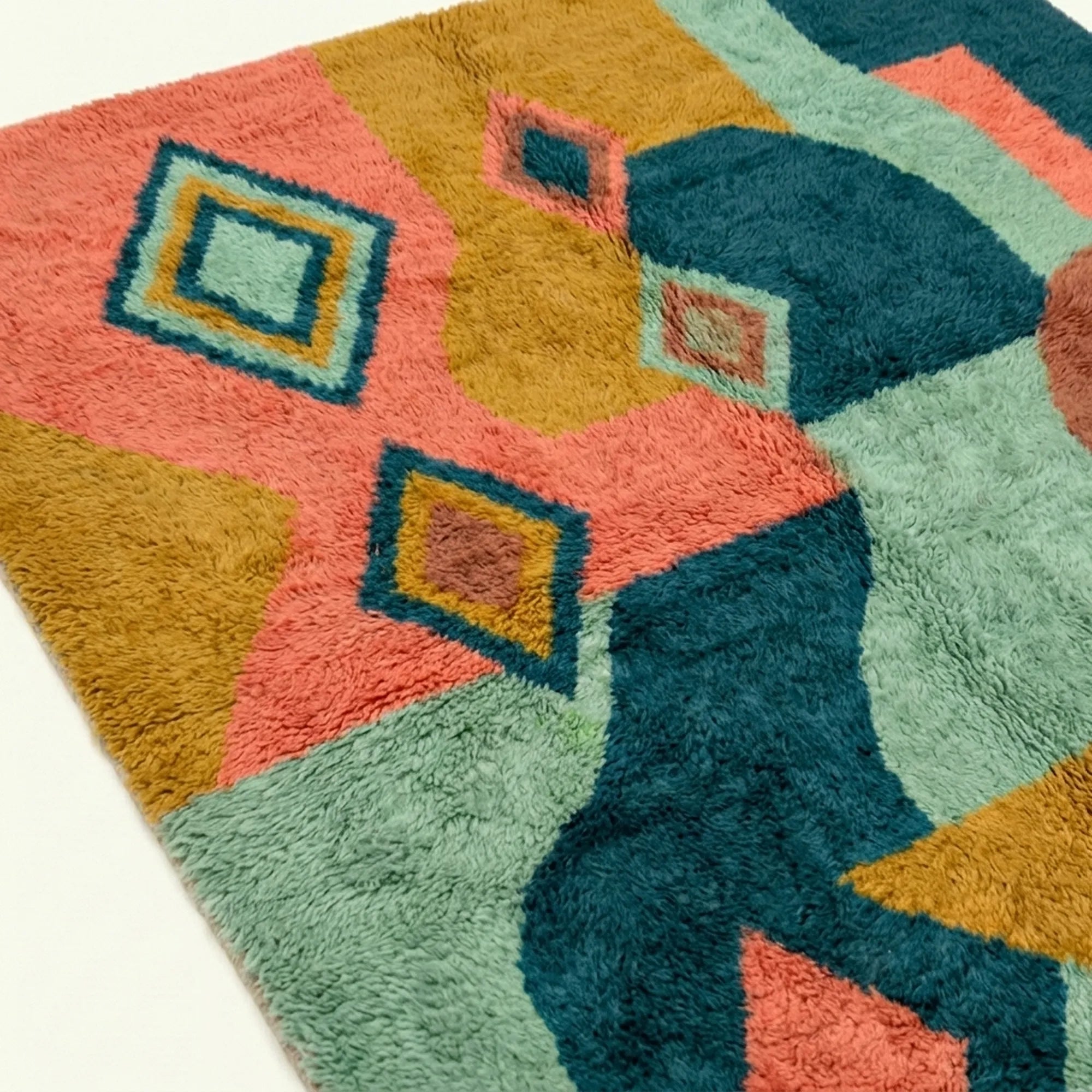 Pattern close-up of Tifawin showing outlined diamonds over teal, coral, ochre and sage color fields